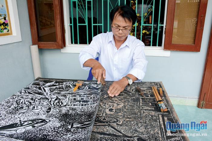 Họa sĩ Phạm Văn Thu sáng tác trên tranh gỗ.