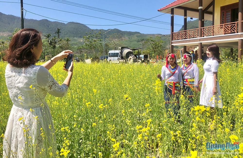 Du khách đến check-in vườn hoa cải còn có cơ hội chụp cùng người bản địa trong trang phục đồng bào Cor truyền thống